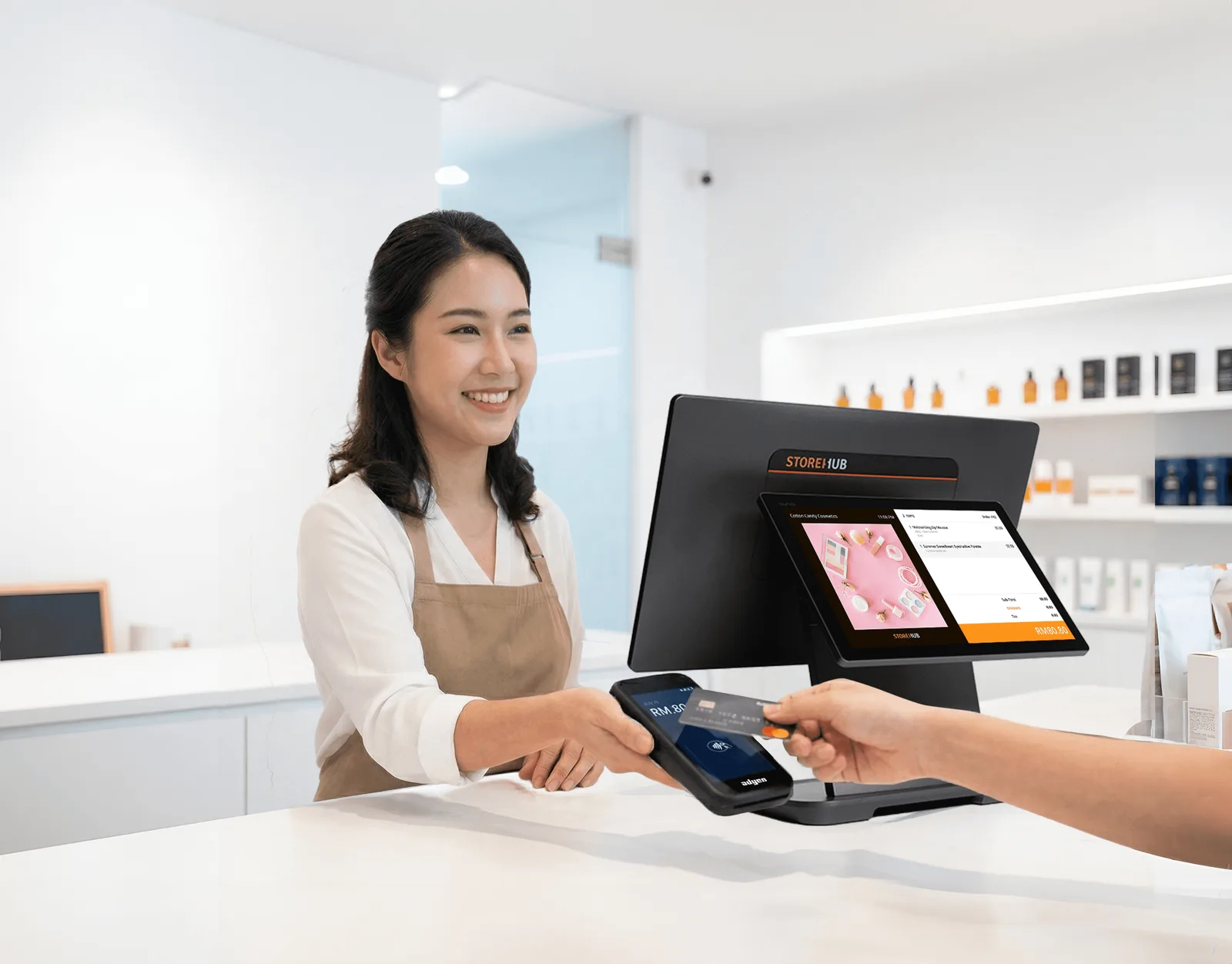 A merchant at her café counter using a StoreHub POS with the AMS1 payment terminal